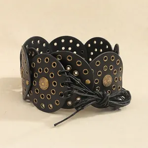 Detail view of Bohemian rivet belt with bronze studs and circular leather patchwork design
