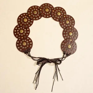 Detail of bohemian leather belt featuring vintage bronze metal studs and rivet discs