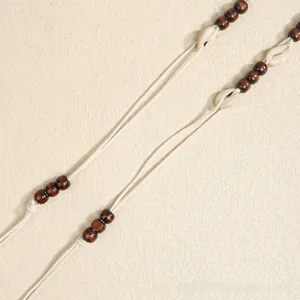 Dettaglio di corda da vita bohémien con conchiglie naturali e perline di legno