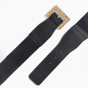 Détail d'une ceinture élastique noire avec boucle carrée dorée et rivets