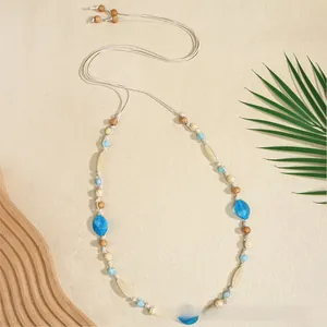 Detail of bohemian woven rope belt with wooden beads and blue resin on beach decor