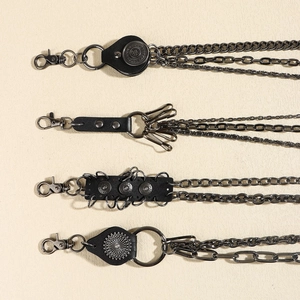 Detail of vintage punk pant chains with multilayer metal links and black leather accents