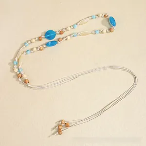 Detail of bohemian braided waist rope featuring ethnic beads and tassel design