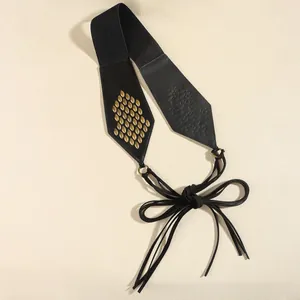 Detail of suede fringe belt featuring gold fish-scale rivets and lace-up tassel closure