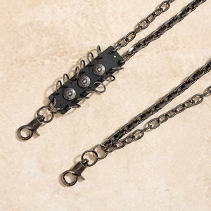 Detail of gunmetal chain link accessory featuring vintage rivets on black leather patches