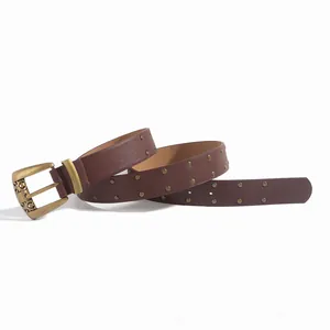 Détail de la ceinture marron foncé en simili cuir avec rivets et boucle baroque ciselée
