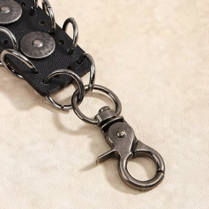 Detailed close-up of retro punk style black leather strap with gunmetal swivel hook
