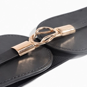 Close-up of black elastic wide belt featuring a luxury interlocking gold metal buckle