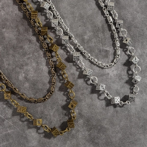 Colliers vintage de style industriel avec pendentifs dés en bronze et argent sur pierre