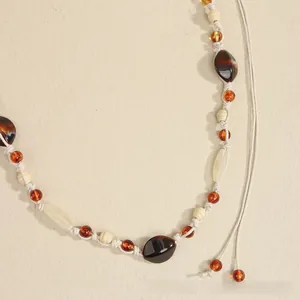 Detail of bohemian hand-woven belt with amber beads and rustic braided tassels