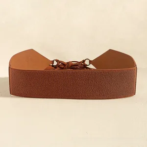 Detail of bohemian caramel elastic waist belt with faux suede lace-up and metal rings
