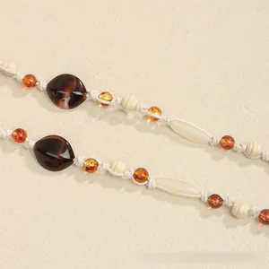 Detailed macro shot of handcrafted bohemian beaded waist rope with marble texture and amber beads