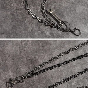 Detail of gun black double-layered metal pant chain with wrench pendant and lobster clasp