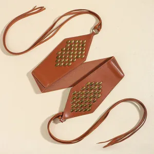 Detail of vintage brown suede waist belt with bronze rivets and shield-shaped metal plates