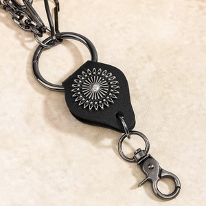 Detail of vintage punk leather waist chain with sunburst metal ornament and gunmetal rings