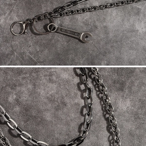 Detail showing industrial wrench pendant with number 8 on silver double chain pants link