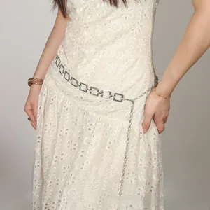 Detail view of silver square link chain waist belt on white lace dress accessory