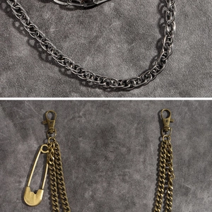 Detail of vintage punk metal trousers chain featuring lobster clasp and safety pin decor