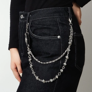 Détail d'une chaîne de pantalon multicouche argentée avec dés et pendentif gothique