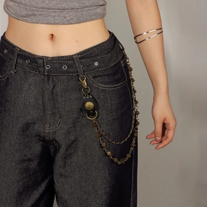Détail de la chaîne de pantalon vintage à double couche en bronze avec boucle en cuir