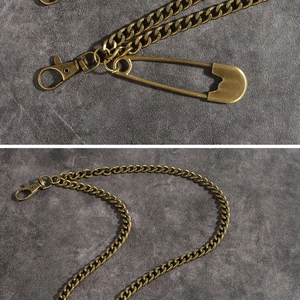 Macro shot of punk style double metal trouser chain with lobster clasp and safety pin
