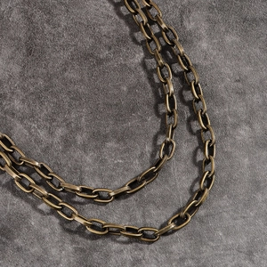 Détail des maillons en métal bronze vintage d'une chaîne de pantalon punk à plusieurs couches