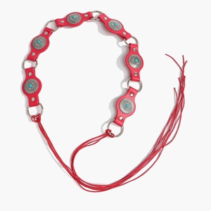 Detail of bohemian red leather belt with silver floral plates and turquoise beads inlay