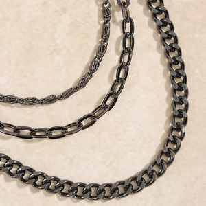 Detailed macro shot of triple-layer black metal pants chains with various link textures