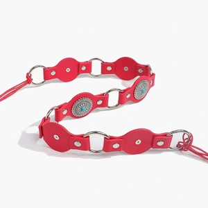 Close-up of red leather bohemian belt with silver concho buckles and turquoise stones