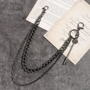 Détail d'une chaîne de pantalon punk double couche avec pendentif clé vintage et plaque