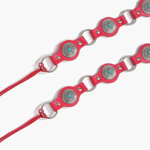 Detail of Bohemian red leather belt with silver sunburst conchos and turquoise stones