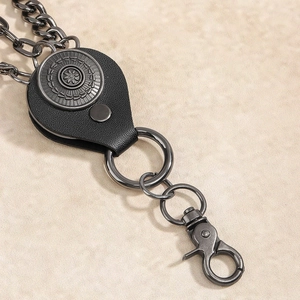 Macro shot of retro gunmetal chain with leather connector and embossed sun motif charm