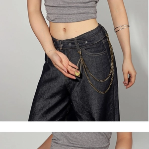 Detail of vintage punk style double-layered metal trousers chain with safety pin pendant