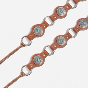 Detail of Bohemian leather belt featuring turquoise inlays, silver conchos and fringe