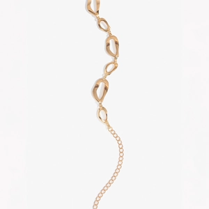 Dettaglio delle maglie metalliche irregolari dorate e della catena di estensione elegante