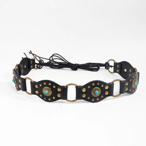 Détail d'une ceinture bohème en cuir noir avec pierres turquoises et anneaux en bronze