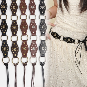 Detail of vintage studded leather belts with metal ring links in multiple colors