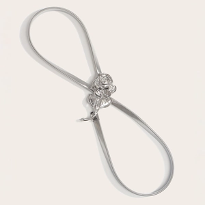 Macro shot of silver metallic spring belt featuring a detailed 3D rose buckle for dresses