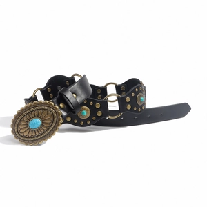 Detalle de cinturón retro western con hebilla turquesa, tachuelas doradas y aros