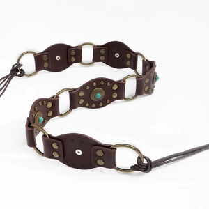 Détail d'une ceinture bohème en cuir marron avec anneaux et incrustations turquoise