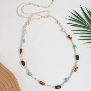 Boho handgewebter Gürtel mit Türkisperlen für Damenkleider auf einem Holztablett