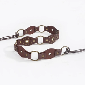 Detail view of retro bohemian waist belt with metal rings, studs and leather patches