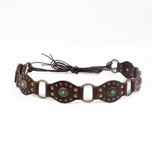 Détail d'une ceinture bohème avec pierres turquoise, anneaux bronze et cordons tressés