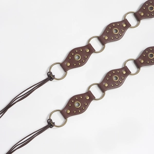 Detail of vintage studded leather belt with bronze rings and long fringe tassels