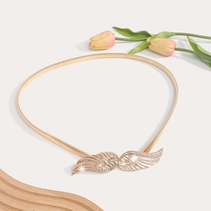 Detailed close-up of gold elastic spring waist chain with sparkling wing buckle