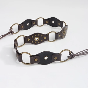 Detail of vintage brown leather belt with bronze rivets and metal ring connectors