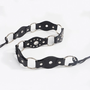 Close-up of punk style belt with oval leather pieces, silver metal rings and rivets