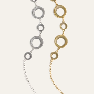 Detail van vintage geometrische metalen taillekettingen in goud en zilver met textuur