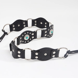 Détail d'une ceinture bohème en cuir noir avec anneaux argentés et clous de tournesol turquoise