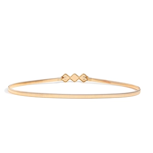 Close-up of golden elastic metal waist belt with geometric diamond buckle design